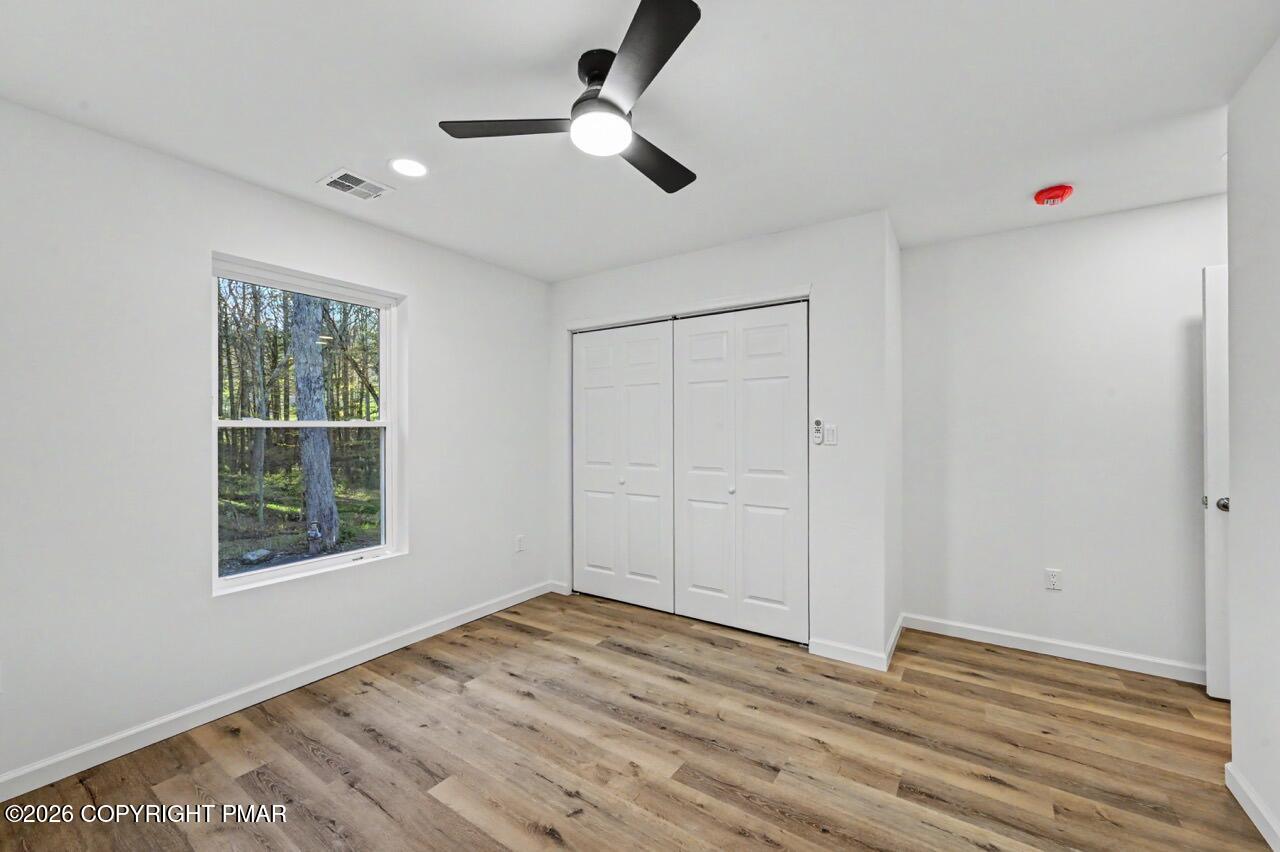 1131 Mink Court Bushkill, PA 18324 - Photo 49 of 81 a view of an empty room with wooden floor and a window