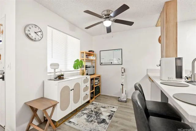 a white kitchen with a stove a sink a dining table and chairs