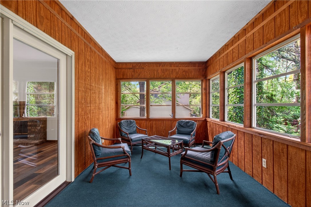 5346 Burlawn Street Northwest Canton, OH 44708 - Photo 14 of 40 Sunroom featuring wood paneling, multiple windows, and a carpeted floor