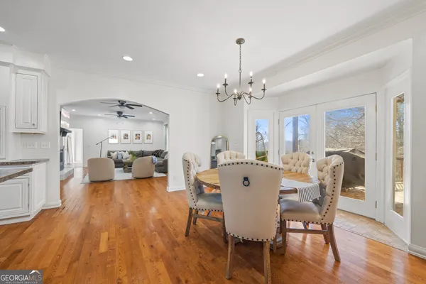 a view of a white house with a large tree next to a yard