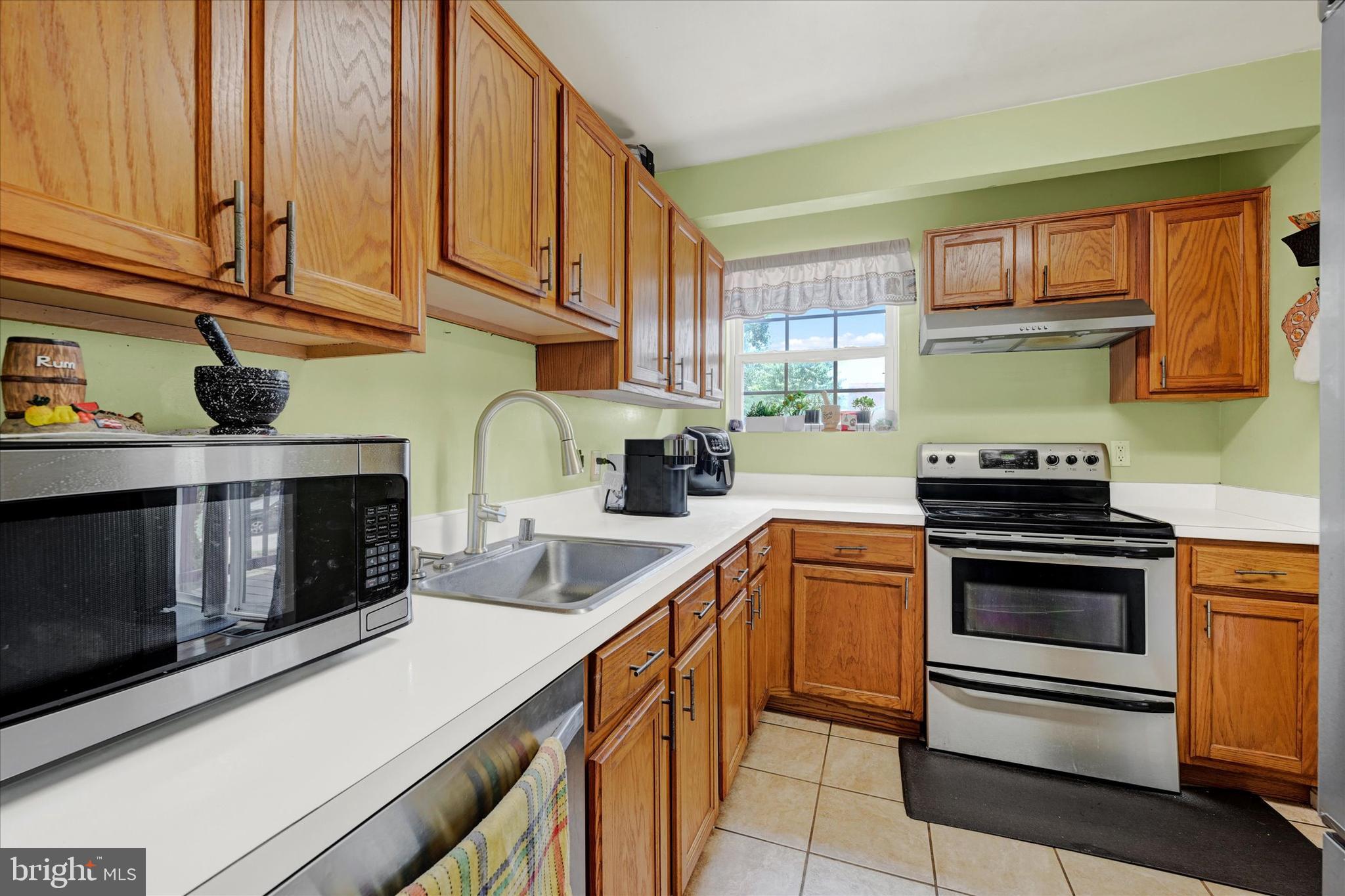 2838 Pennsylvania Avenue Baltimore, MD 21227 - Photo 12 of 32 a kitchen with stainless steel appliances granite countertop a stove a sink and a microwave