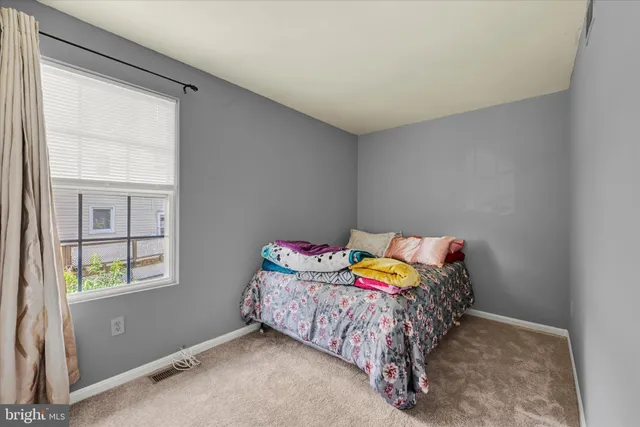 a bed sitting in a bedroom next to a window