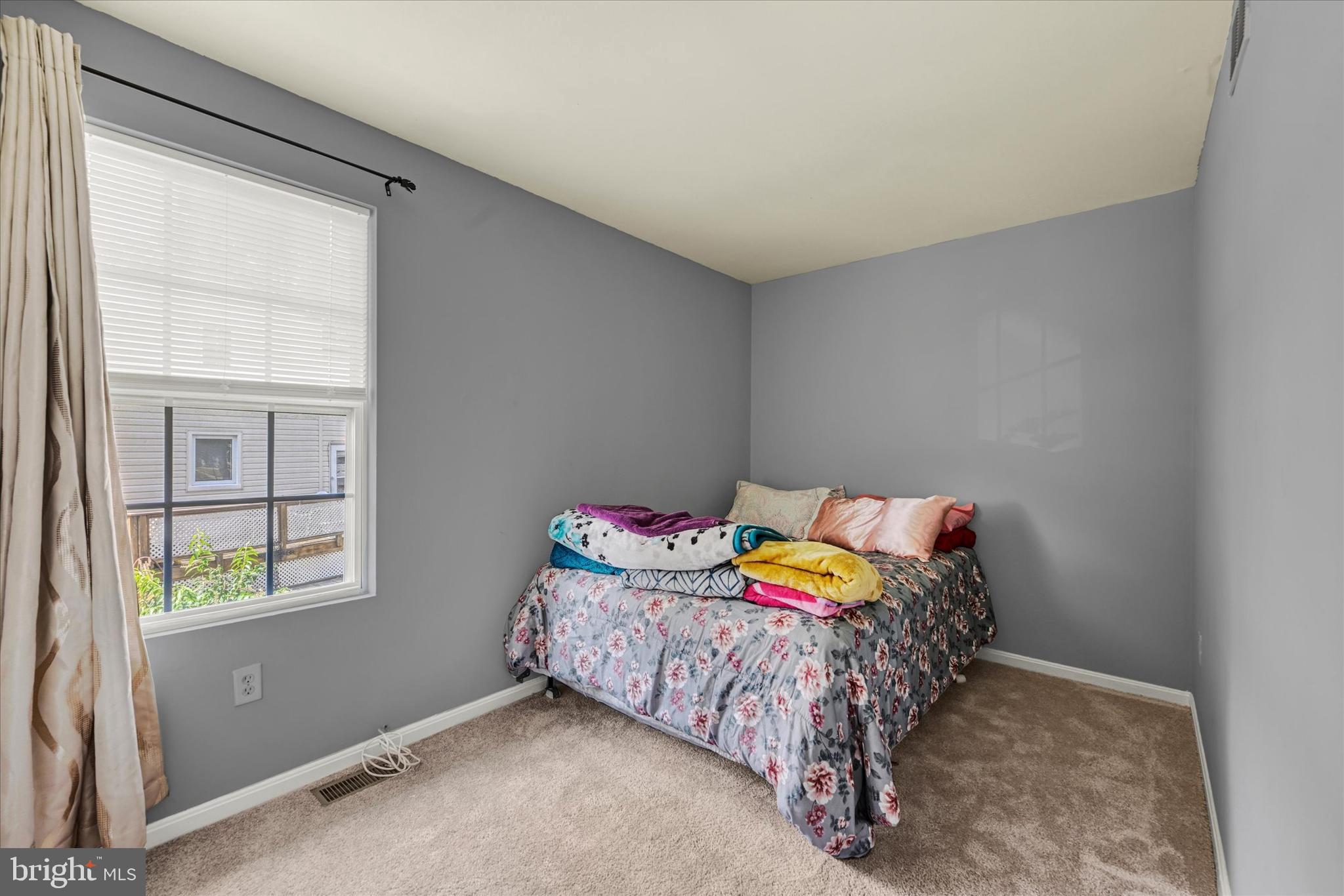 2838 Pennsylvania Avenue Baltimore, MD 21227 - Photo 14 of 32 a bed sitting in a bedroom next to a window