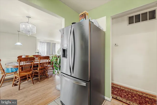 a kitchen with stainless steel appliances a refrigerator and a wooden floor