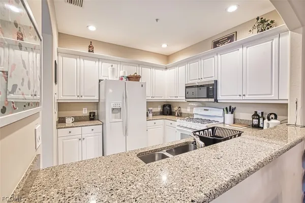 a kitchen with stainless steel appliances granite countertop a refrigerator sink and stove
