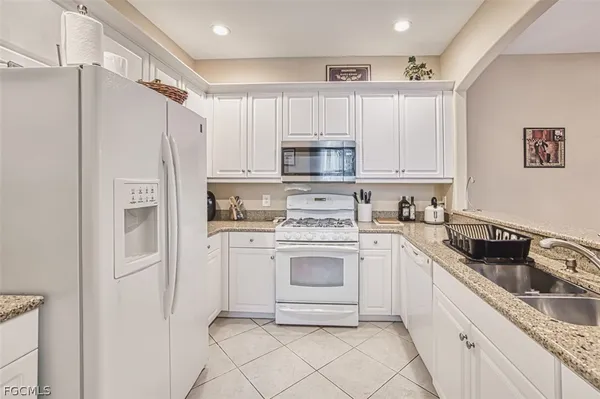 a kitchen with white cabinets and white appliances