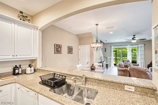 a kitchen with granite countertop a sink stove and cabinets