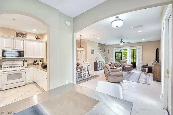a large white kitchen with a large window and stainless steel appliances