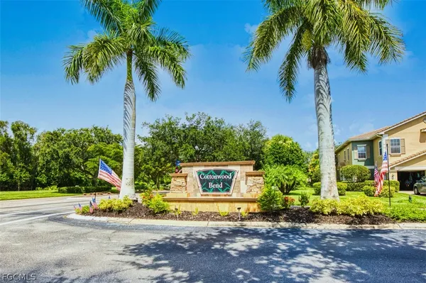 a view of a house with palm trees and a small yard