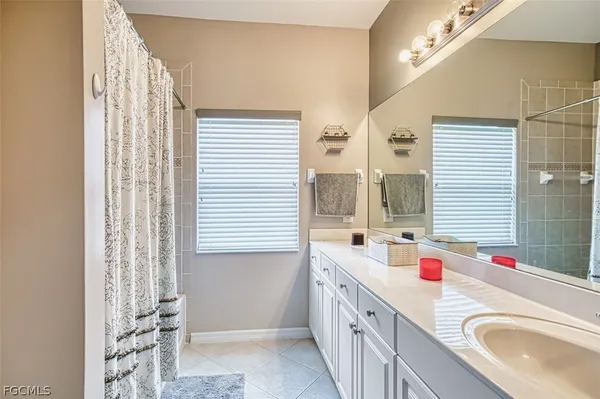a bathroom with a granite countertop sink a mirror and a bathtub