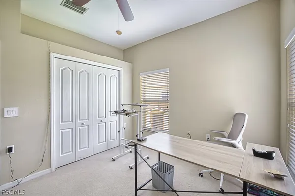 a view of a workspace with furniture and a window
