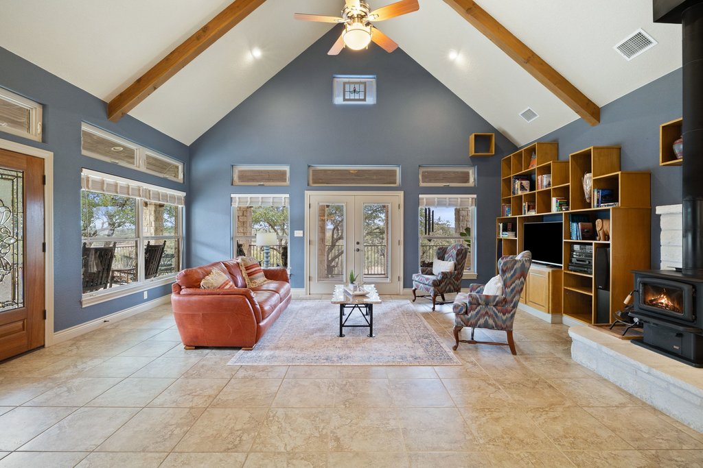 232 Crooked Oak Round Mountain, TX 78663 - Photo 10 of 40 Living area featuring a wood stove, high vaulted ceiling, plenty of natural light, ceiling fan, and beamed ceiling
