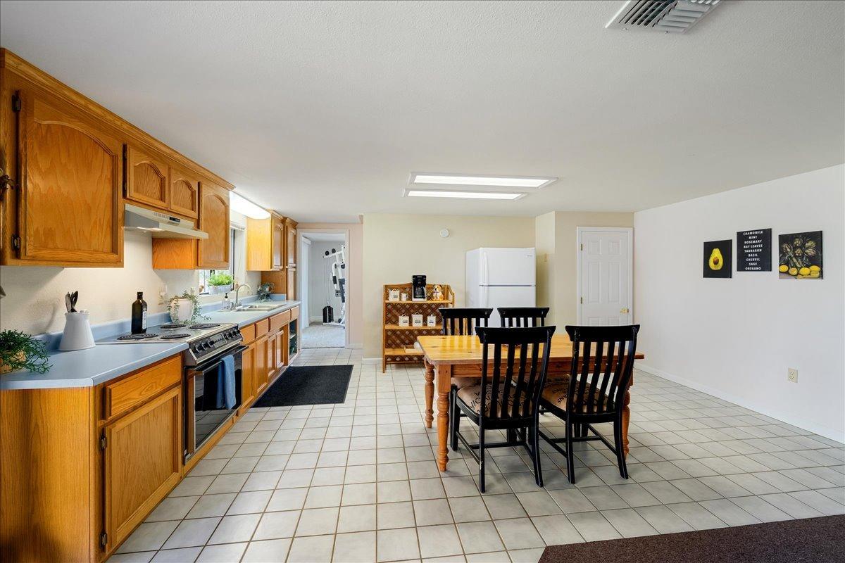 13936 Oak Ridge Road Penn Valley, CA 95946 - Photo 39 of 83 a kitchen with stainless steel appliances granite countertop table chairs sink and cabinets
