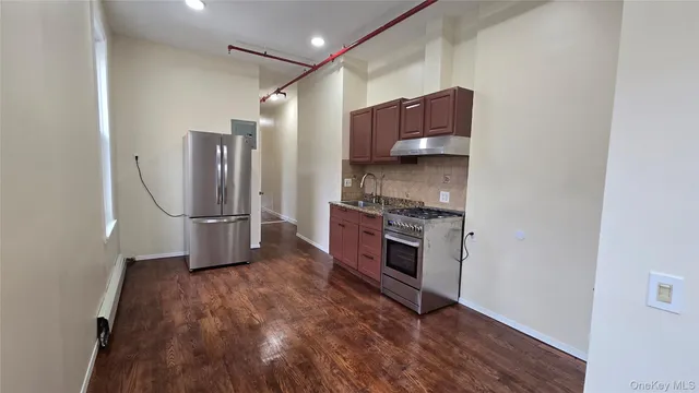 a kitchen with granite countertop a refrigerator and a stove