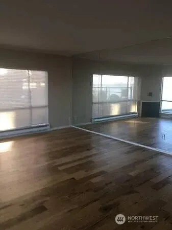 a view of empty room with wooden floor
