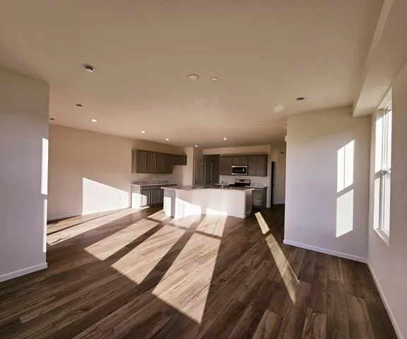 a large bedroom with wooden floor and a sink