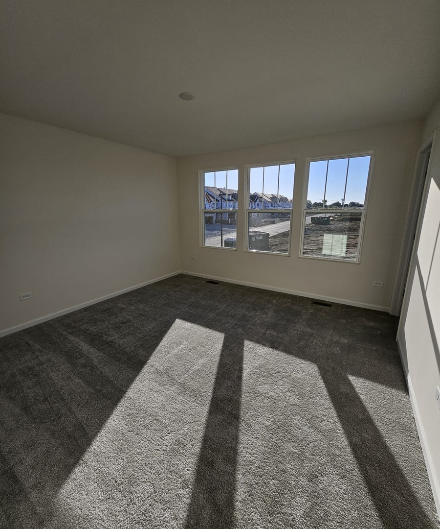 2212 Horseshoe Circle, Unit 2212 Plainfield, IL 60585 - Photo 8 of 12 an empty room with wooden floor and windows