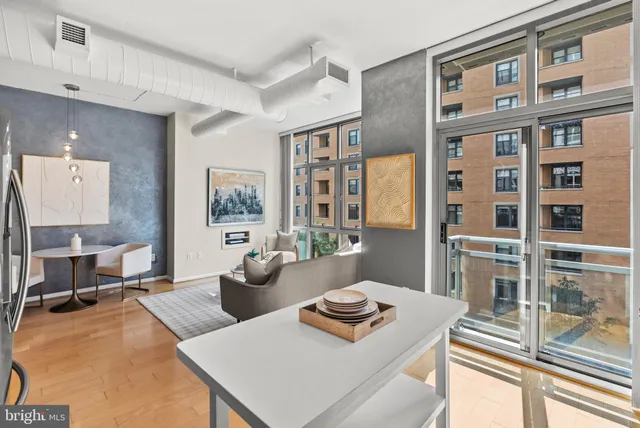 a living room with furniture stove and large window