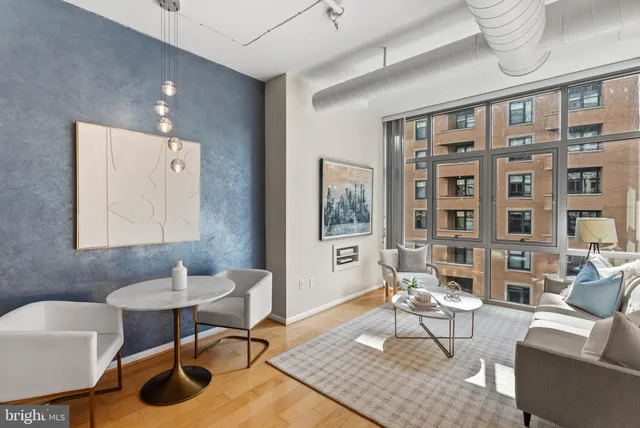 a living room with furniture a rug and a large window