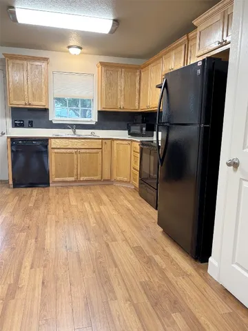 a kitchen with granite countertop a refrigerator and a sink