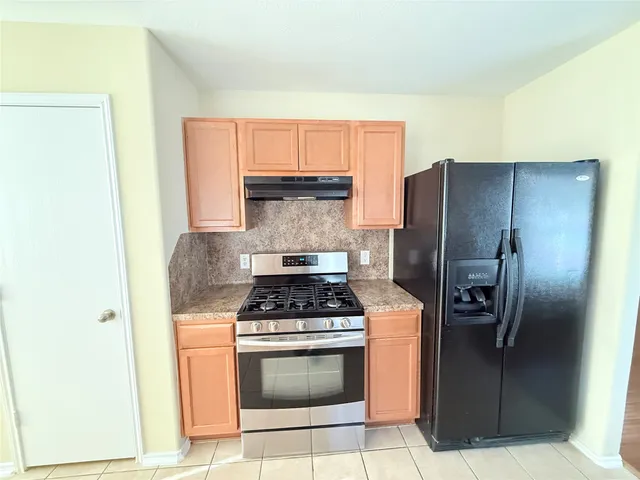 a kitchen with stainless steel appliances granite countertop a refrigerator and a stove