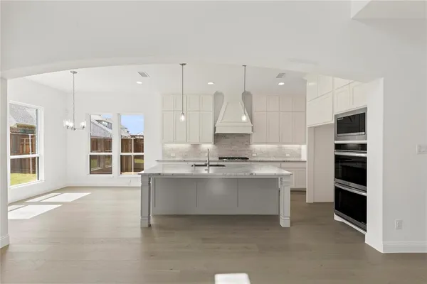 a large kitchen with kitchen island a stove a sink and a refrigerator