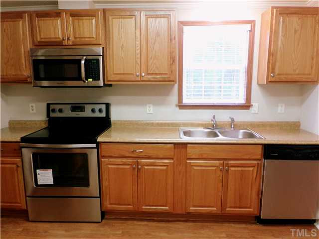 295 Massengill Pond Road Angier, NC 27501 - Photo 8 of 25 a kitchen with stainless steel appliances granite countertop a stove a microwave and a white cabinets