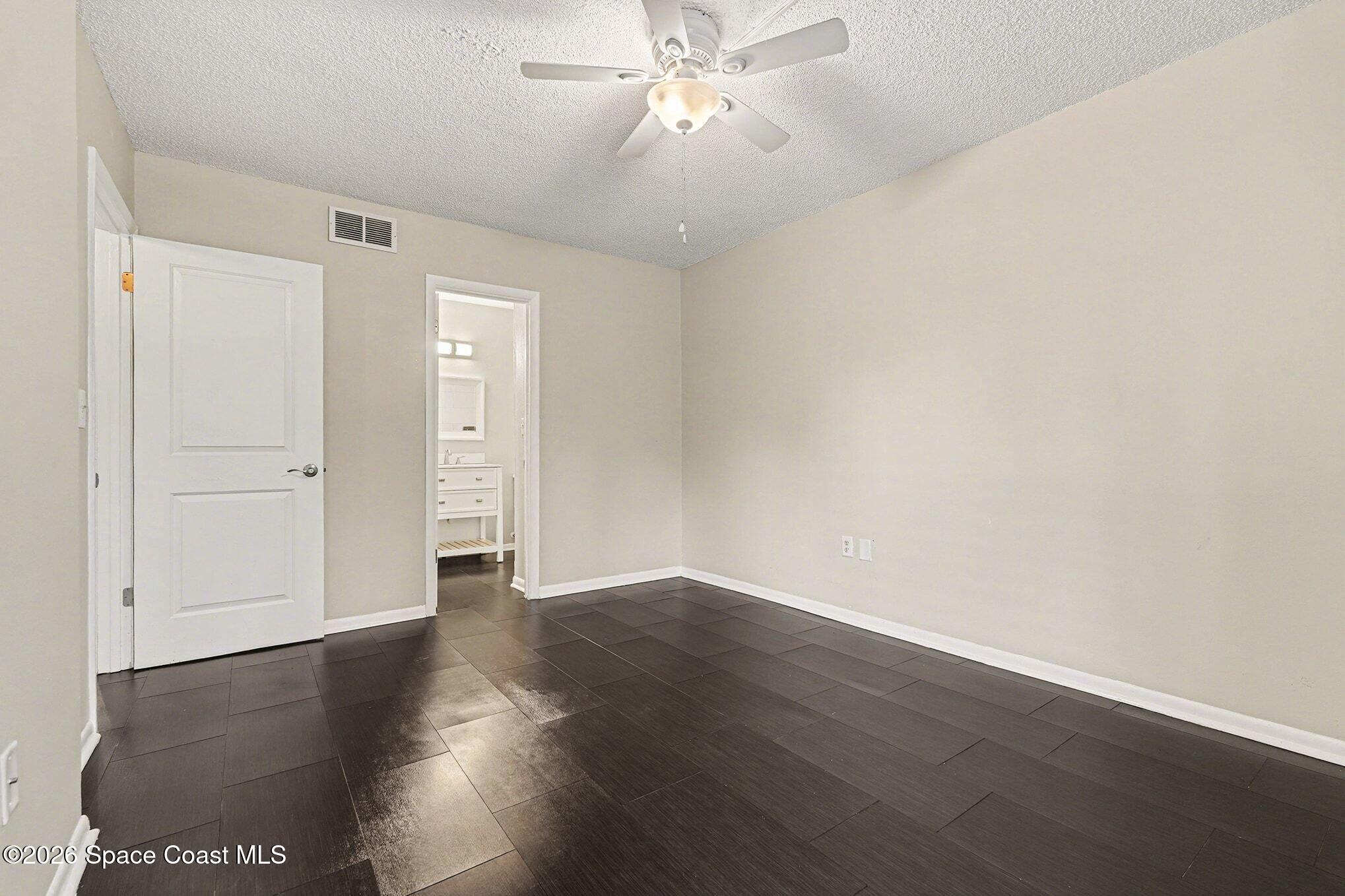 1011 Clearmont Street Northeast, Unit 1022 Palm Bay, FL 32905 - Photo 11 of 16 an empty room with wooden floor and windows