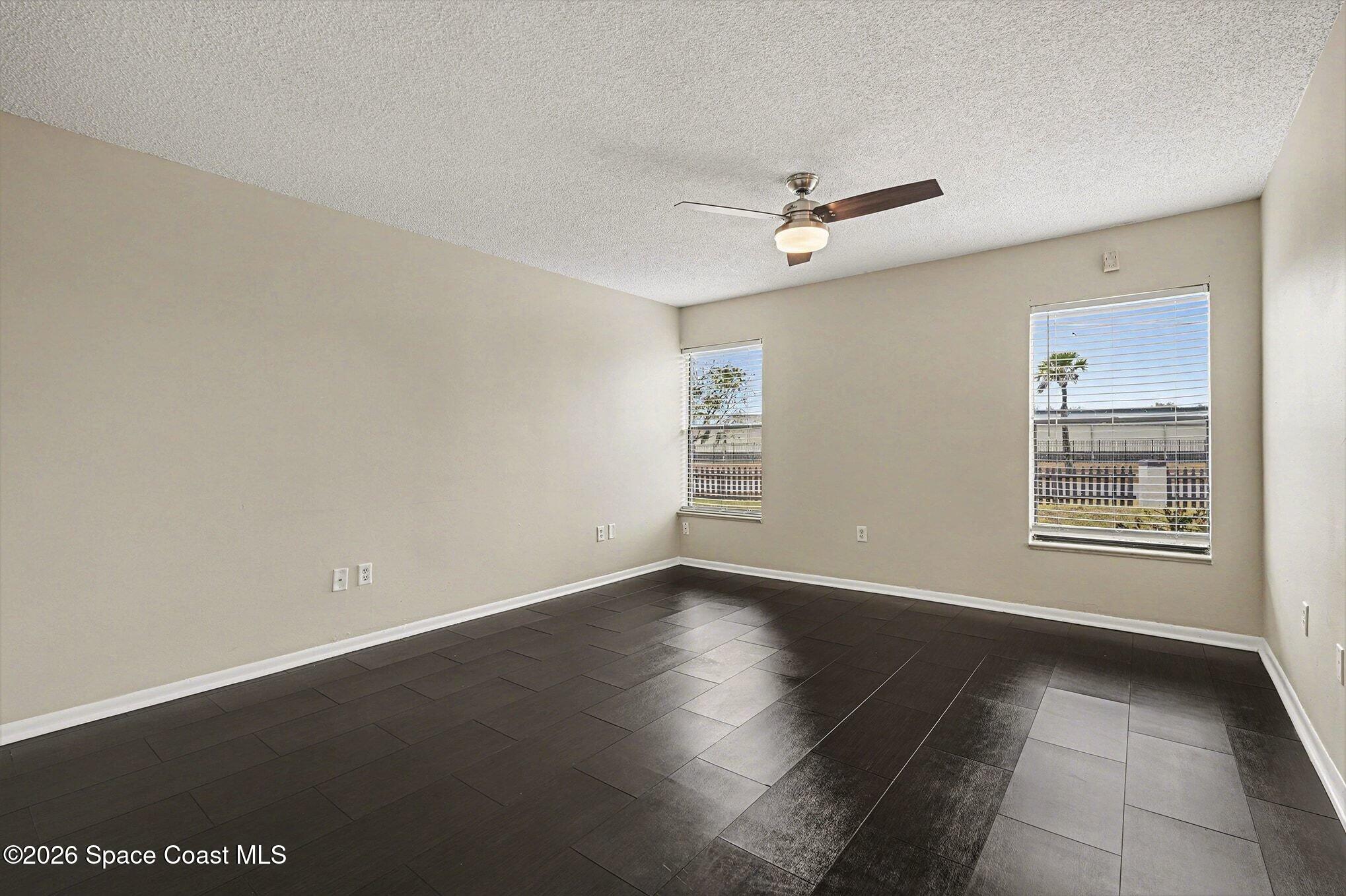 1011 Clearmont Street Northeast, Unit 1022 Palm Bay, FL 32905 - Photo 5 of 16 an empty room with windows and ceiling fan