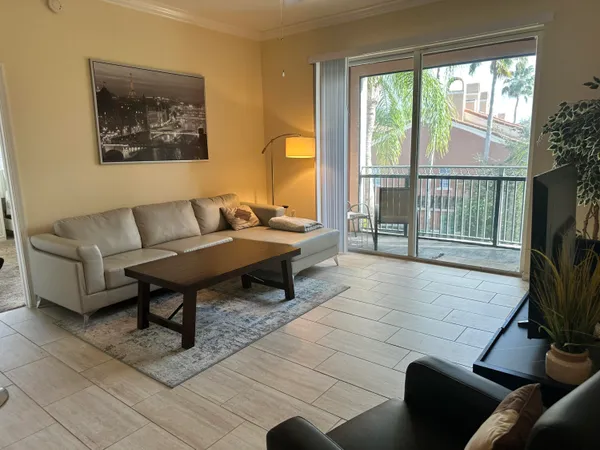 a living room with furniture and a floor to ceiling window