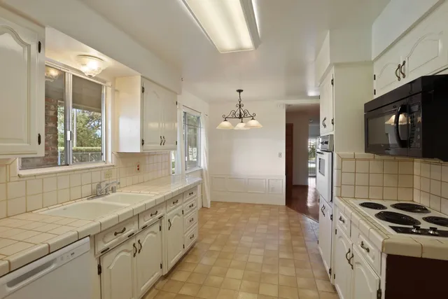 a kitchen with a sink stove top oven and refrigerator