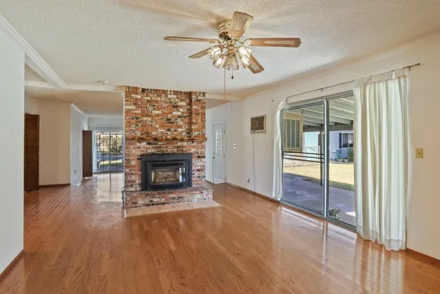 wooden floor fireplace and windows in an empty room