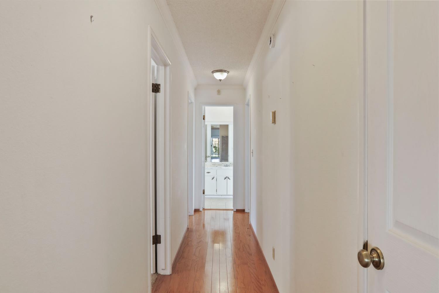 13495 Live Oak Road Lodi, CA 95240 - Photo 32 of 47 a view of a hallway with wooden floor and a bathroom