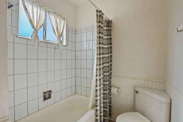 a bathroom with a toilet and a shower