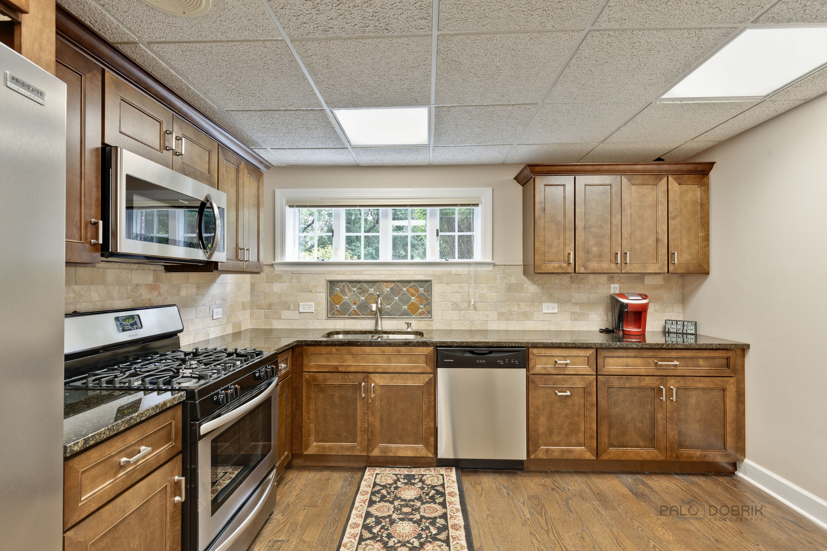 575 West Windsor Road Inverness, IL 60067 - Photo 48 of 54 a kitchen with stainless steel appliances granite countertop a sink a stove a microwave and cabinets