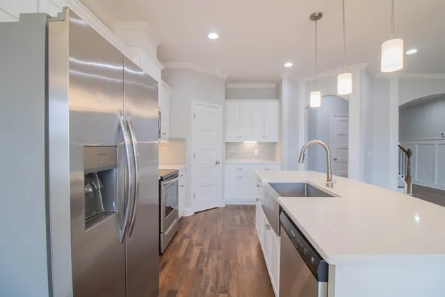a kitchen with a refrigerator a sink and wooden floor