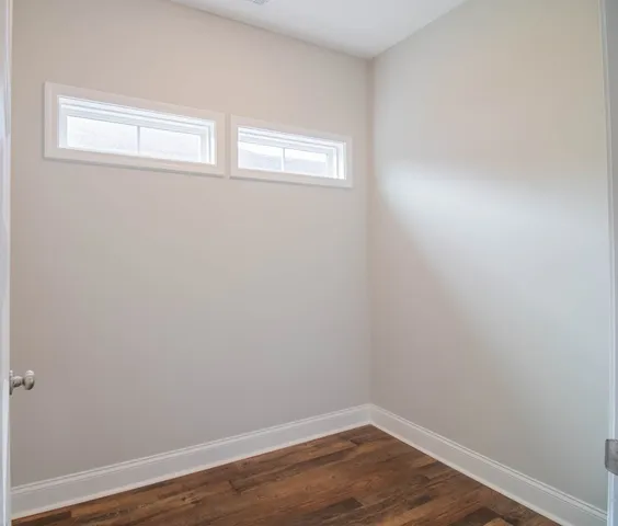 a view of a small space with wooden floor and a window