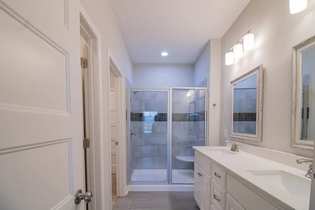a bathroom with a shower sink and mirror