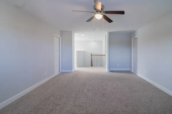 an empty room with a ceiling fan and a window