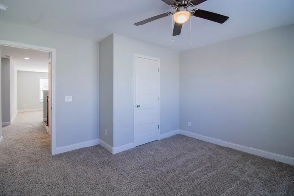 a view of an empty room and chandelier fan