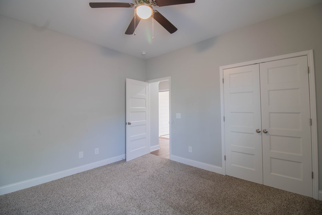 9605 Capot Drive Midland, GA 31820 - Photo 6 of 38 an empty room with a empty space and a ceiling fan