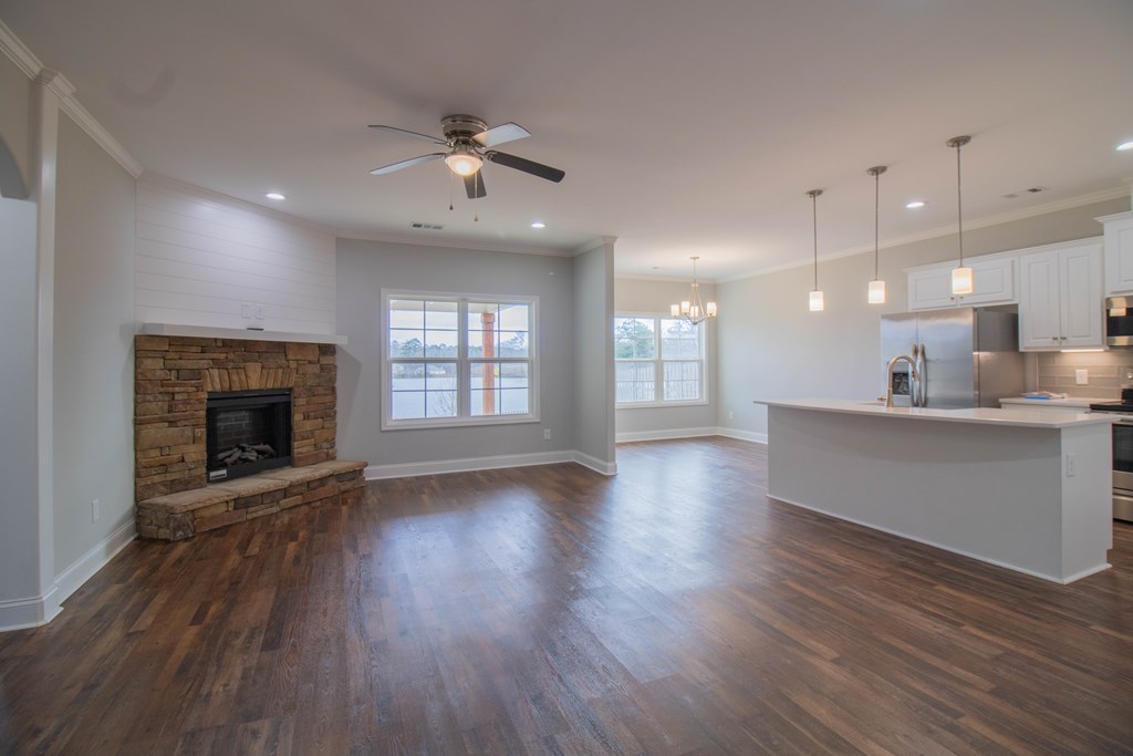 9605 Capot Drive Midland, GA 31820 - Photo 7 of 38 an empty room with wooden floor and a kitchen