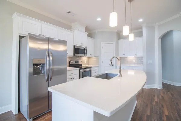 a kitchen with sink refrigerator and microwave