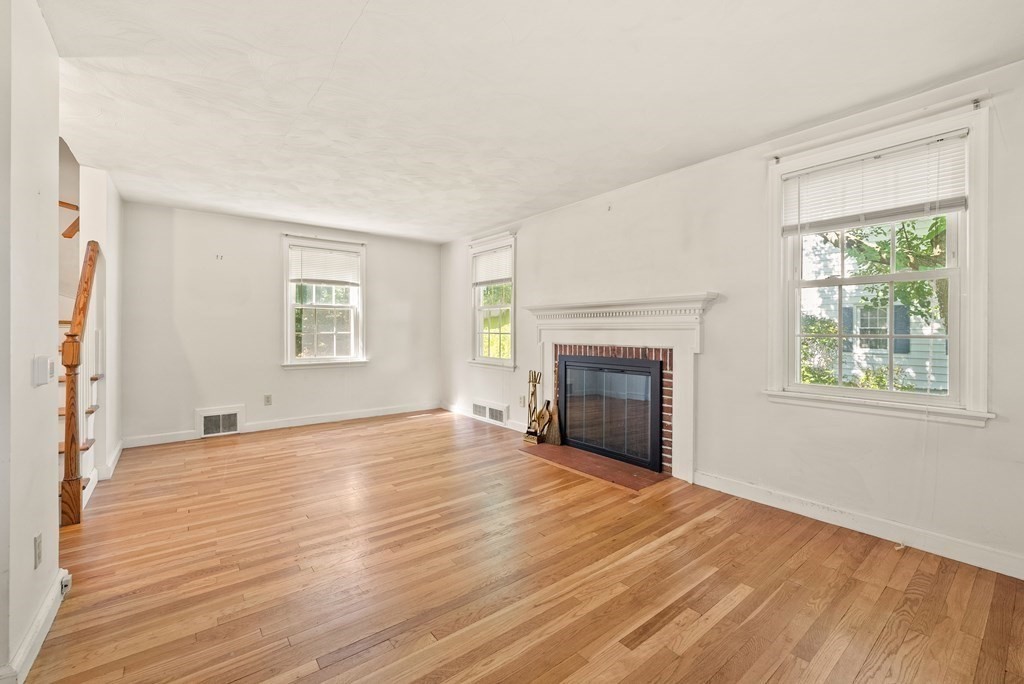 291 Maple Road Longmeadow, MA 01106 - Photo 4 of 26 an empty room with wooden floor fireplace and windows