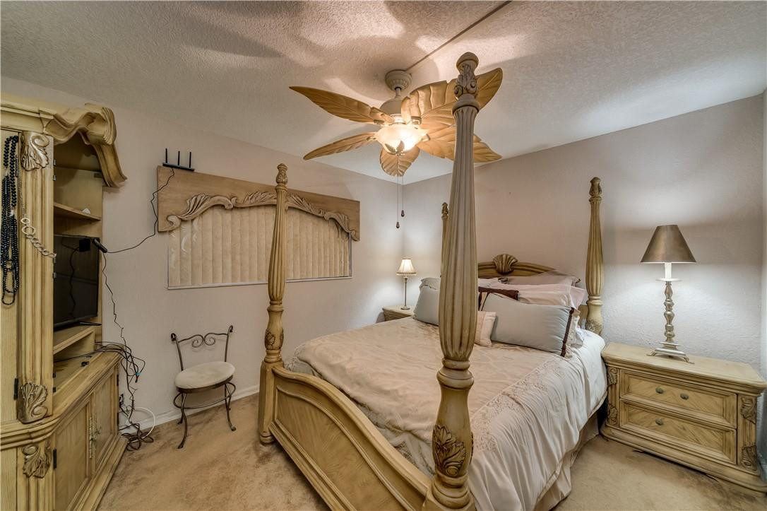3955 North Nob Hill Road, Unit 408 Sunrise, FL 33351 - Photo 13 of 34 a bedroom with a bed and a chandelier