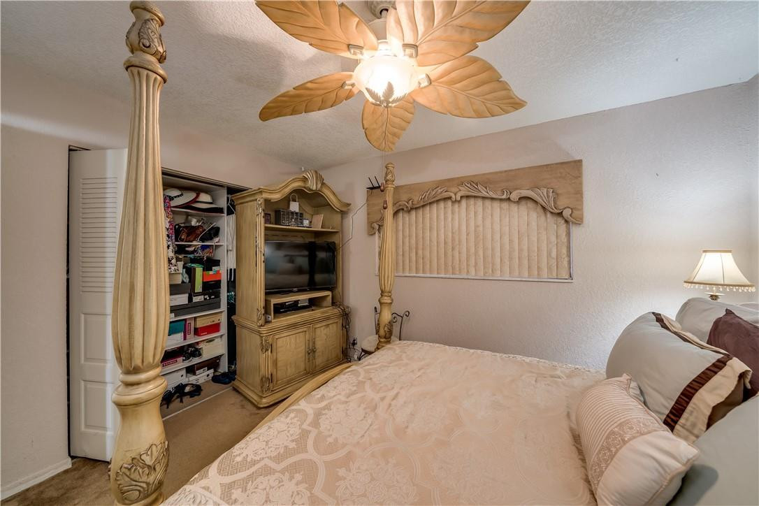 3955 North Nob Hill Road, Unit 408 Sunrise, FL 33351 - Photo 15 of 34 a bedroom with a bed and a chandelier