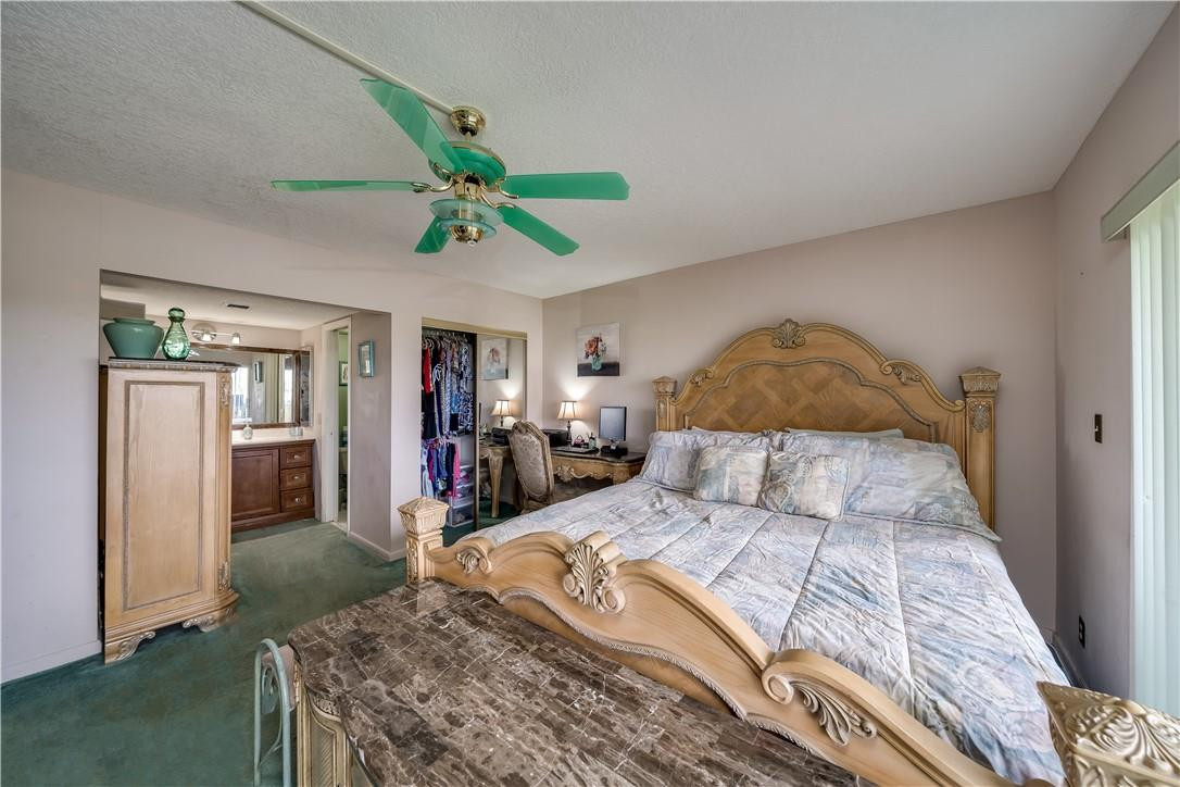 3955 North Nob Hill Road, Unit 408 Sunrise, FL 33351 - Photo 25 of 34 a bed in a bedroom next to a window