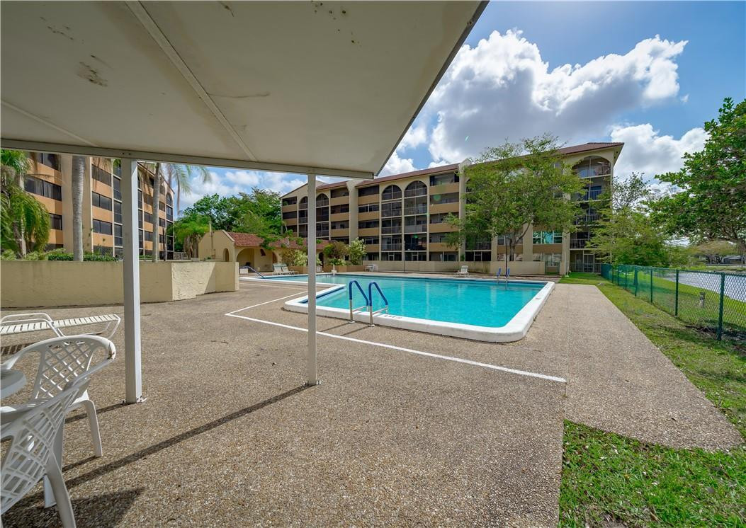 3955 North Nob Hill Road, Unit 408 Sunrise, FL 33351 - Photo 31 of 34 a view of a swimming pool with a patio