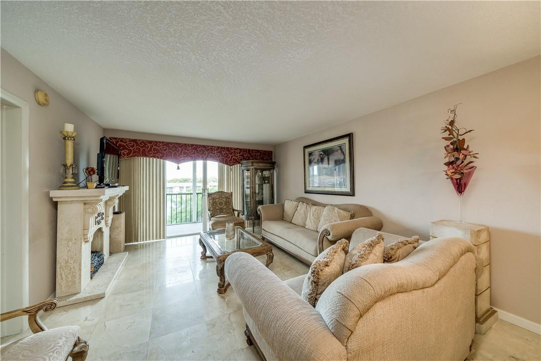 3955 North Nob Hill Road, Unit 408 Sunrise, FL 33351 - Photo 4 of 34 a living room with furniture a fireplace and a large window