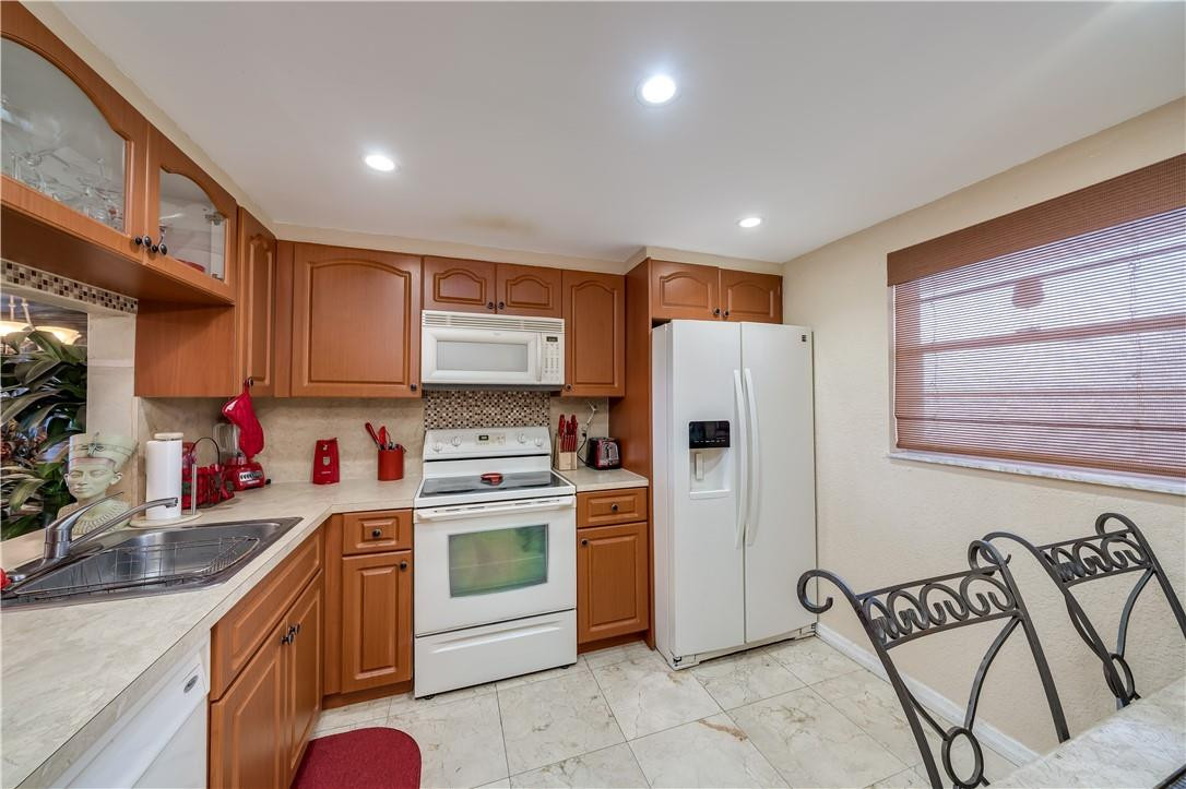 3955 North Nob Hill Road, Unit 408 Sunrise, FL 33351 - Photo 8 of 34 a kitchen with granite countertop a refrigerator stove top oven a sink and dishwasher
